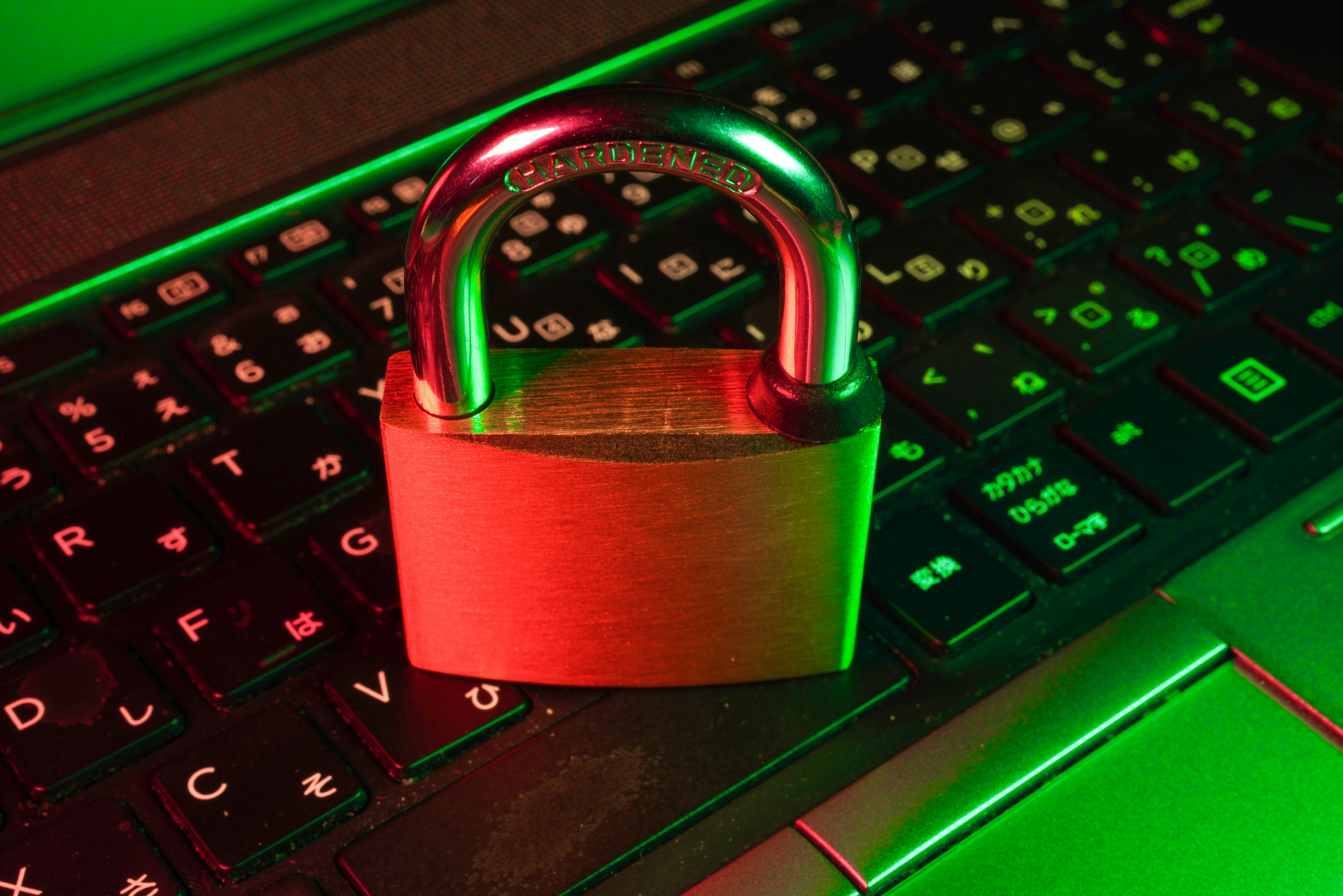 Cadenas rouge sur un clavier d'ordinateur — la défense en profondeur d'un agent IA connecté à la messagerie : filtres d'entrée, gates d'approbation, cloisonnement